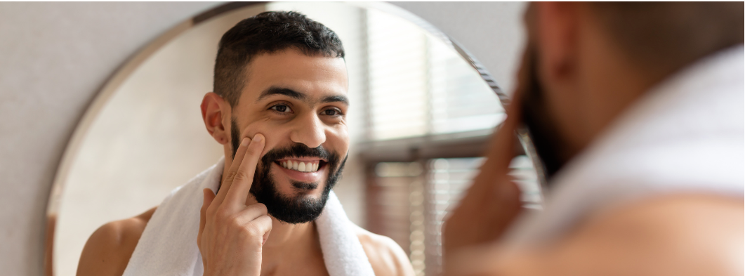 man taking care of his face/skin in mirror