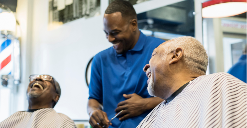 Barber laughing with 2 clients