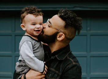 man holding curly haired boy