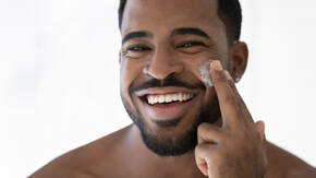 Man using facial moisturizer